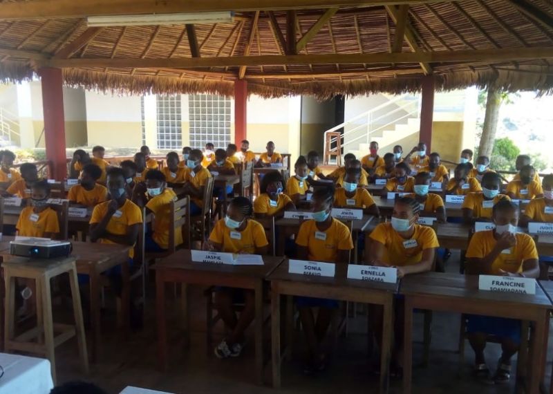 Wings of Change students in the open-air classroom in Nosy Be during a remote lesson, projector on the desk
